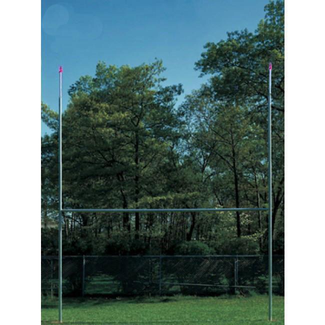 Semi-permanent rugby goal posts installed on a field, viewed against trees and sky
