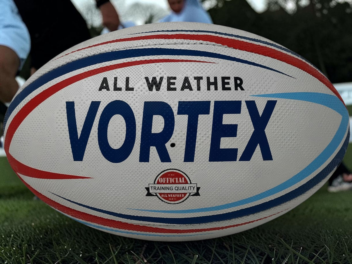 Ruggers Rugby Supply KooGa Vortex all-weather rugby practice ball with red and blue graphic details on a grass pitch